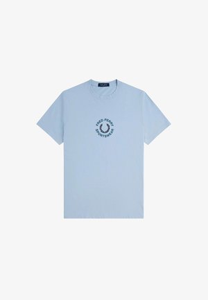Hellblaues Baumwoll-T-Shirt mit kurzen Ärmeln, das ein navyblaues, kreisförmiges 'Fred Perry Sportswear'-Logo und ein Lorbeerdesign auf der Brust zeigt.