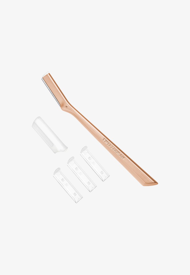 Rose gold eyebrow razor with a protective cap and three replacement blades arranged on a white background.