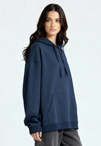 Felpa con cappuccio blu navy in tessuto morbido, con tasca frontale, cappuccio con coulisse regolabile e polsini e orlo a costine.