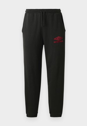 Pantaloni da tuta neri con cintura elastica e polsini, tasche laterali e logo Umbro rosso sulla coscia sinistra.