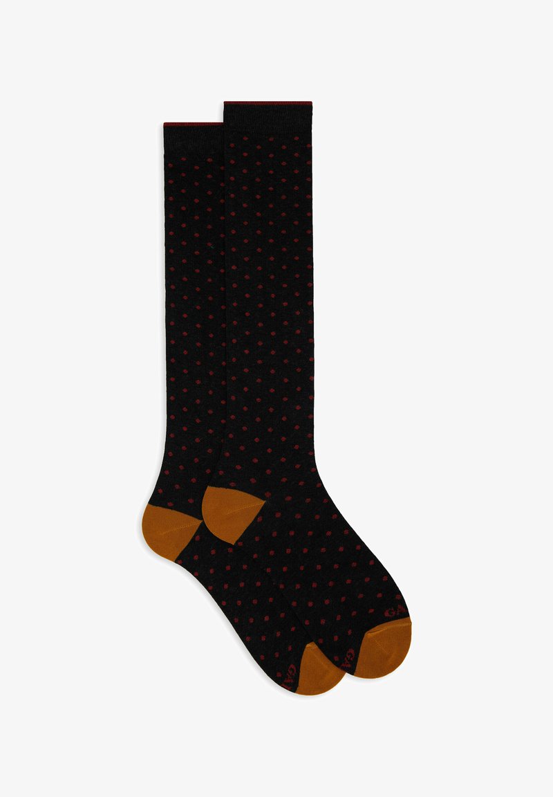 Calze nere al ginocchio con pois rossi, aree del dito e del tallone in contrasto marrone, texture liscia e dettaglio a coste sulla parte superiore.