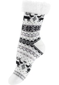 Calza bianca lavorata a maglia con un risvolto soffice bianco, decorata con renne nere, fiocchi di neve e motivi geometrici in grigio e viola.