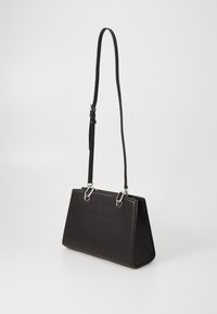 Sac à main en cuir noir avec une forme structurée, des poignées courtes et longues réglables, des accents en métal argenté et une surface lisse.