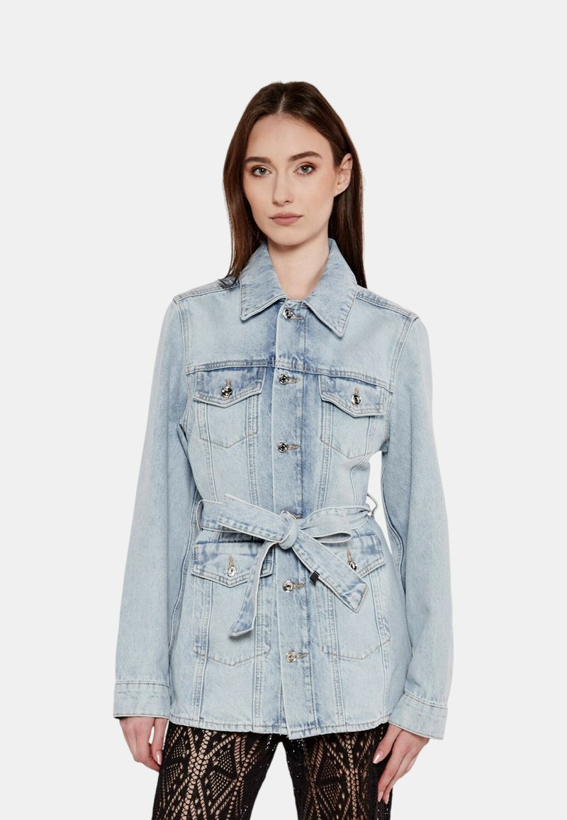 Giubbotto in denim azzurro con vita regolabile da cintura, colletto a punta e accessori in argento. Presenta due tasche sul petto e una vestibilità strutturata.
