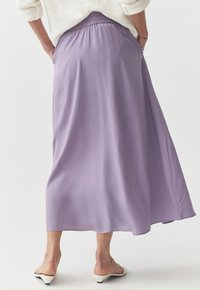 Lavendli maxi seelik sileda tekstuuriga, elastse vöökoha ja voolava disainiga. Omab küljetaskuid ja sirget alläänt.