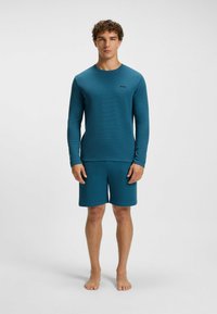 Teal long-sleeve shirt and matching shorts made of textured fabric. Features a small logo on the chest, round neck, and relaxed fit.