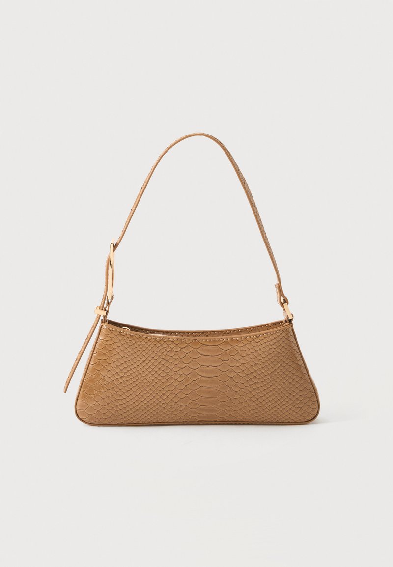 Petit sac à main beige avec texture de peau de reptile embossée et une seule bandoulière réglable sur un fond uni.