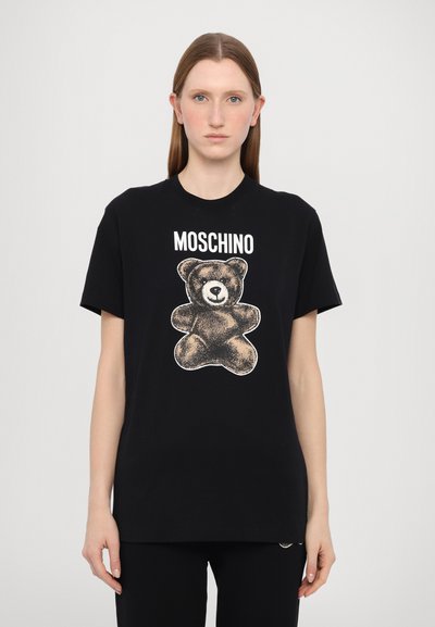 T-shirt din bumbac negru cu un grafic al unui ursuleț de pluș în nuanțe de maroniu și alb, având textul "MOSCHINO" deasupra. Design cu mâneci scurte și guler rotund.