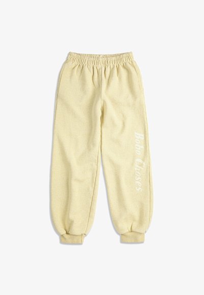 Pantalon de jogging en polaire beige clair avec taille et poignets élastiques, présentant le texte « Bobo Choses » imprimé verticalement sur la jambe droite.