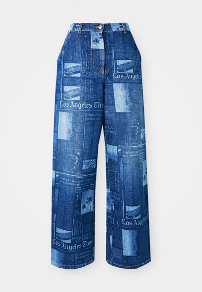 Jeans azuis de perna larga de cintura alta com estampa de jornal, incluindo texto "Los Angeles Times" e imagens de palmeiras.