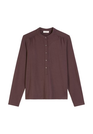 Maglietta a maniche lunghe in un profondo malva, caratterizzata da un colletto henley con bottoni e dettagli arricciati sulle spalle. Tessuto morbido con branding minimale.