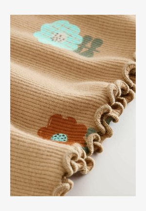 Rebrasta bež tkanina s cvjetnim uzorcima koja sadrži plavi i smeđi cvijet. Rubovi imaju detalj nabrane čipke.