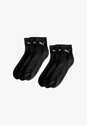 Six black ankle socks with white Puma logos on the cuffs, arranged in two groups of three on a white background.