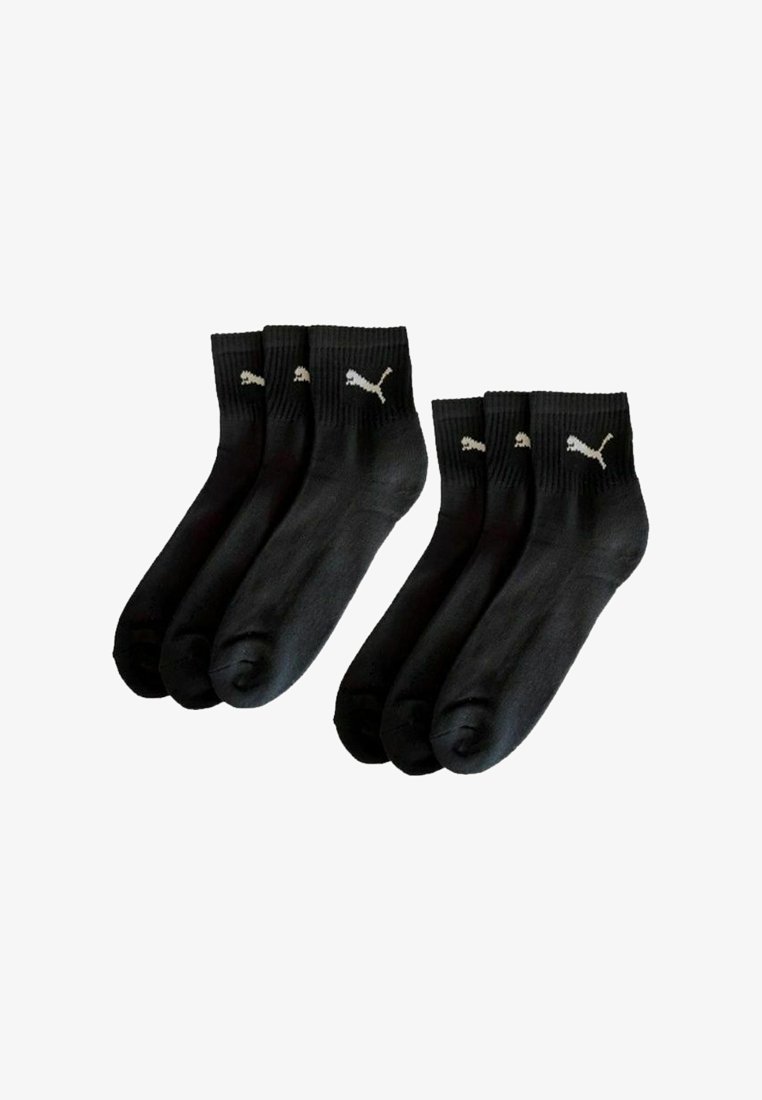 Sechs schwarze Knöchelsocken mit weißen Puma-Logos an den Bündchen, in zwei Gruppen zu je drei auf einem weißen Hintergrund angeordnet.