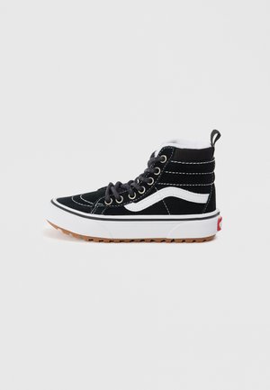 Sneaker alta nera in suede, con accenti bianchi, punta tonda, suola in gomma e occhielli rinforzati. Superficie testurizzata con dettagli di cucitura.