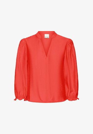 Punane pluus V-kaelusega, puffvarrukatega ja kogutud mansettidega. Valmistatud kerge kangaga, millel on sile tekstuur ja lihtne disain.