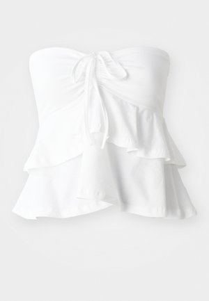 Haut blanc sans bretelles avec un corsage ajusté et un lien à l'avant, orné de volants superposés à l'ourlet, fabriqué à partir d'un tissu doux et léger.