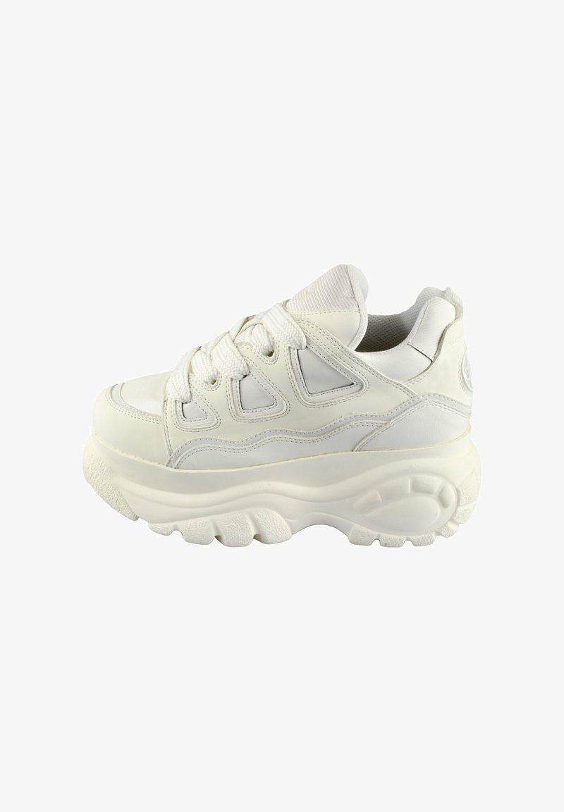 Fehér sportcipő, vastag talppal, struktúrált bőrrel, fűzős kialakítással és éles kivágásokkal az oldalán a légáteresztés és a stílus érdekében.