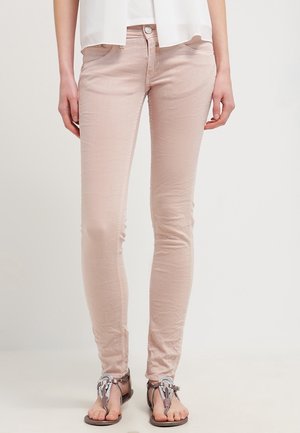 Jeans skinny rosa chiaro realizzati in cotone testurizzato. Presentano un classico design a cinque tasche e chiusura con bottone frontale, abbinati a sandali piatti.