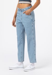Světle modré volné džíny z denimu, které mají dvě přední kapsy, vysoký pas a viditelné švy podél bočních švů.
