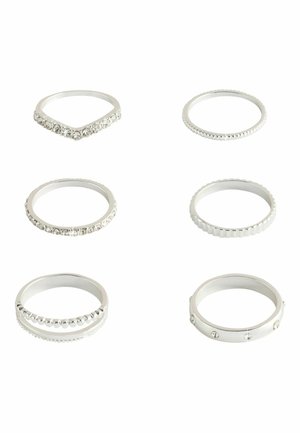 Six silver rings with various designs including smooth bands, textured edges, and embedded clear stones arranged on a white background.