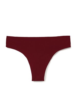 Effen donkerrode dames string onderbroek plat neergelegd op een witte achtergrond.