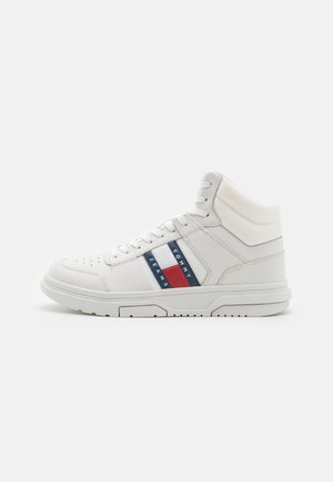 Sneakers bianchi alto realizzati in pelle con suole in gomma. Presentano accenti a strisce blu, rosse e bianche e perforazioni circolari sulla punta.