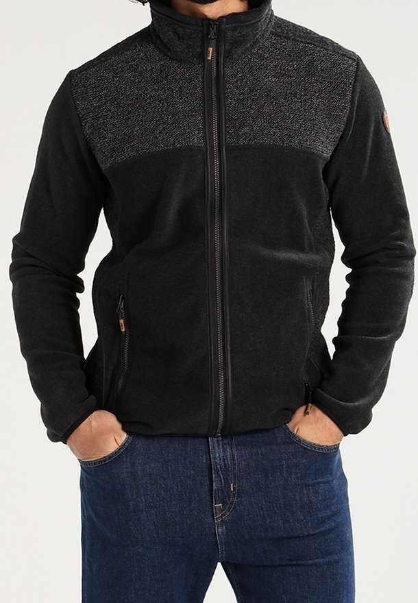 Schwarze Reißverschlussjacke mit strukturiertem grauem Einsatz oben, zwei Seitentaschen und hohem Kragen. Weicher Stoff und körpernahe Passform.