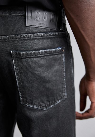 Mustad denim särgid tekstureeritud viimistlusega, millel on nahast silt "ICON" ja tagakotil äärtega tikand.