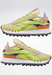 Baskets multicolores avec une tige en mesh et synthétique. Présentent des accents jaunes, verts, orange et noirs, avec une semelle intermédiaire blanche et une semelle extérieure noire.