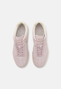 Light pink suede sneakers with cream accents, round toe, lace-up design, and subtle branding on the side. Textured rubber sole.