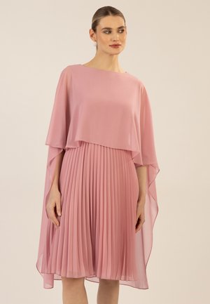 Plissiertes Kleid in Hellrosa mit einem fließenden Cape-Overlay. Hergestellt aus leichtem Stoff, mit rundem Ausschnitt und knielangem Saum.