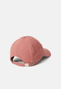 Boné de beisebol de algodão cor-de-rosa empoeirado com faixa ajustável de fivela de metal, apresentado em um fundo branco liso, visto do ângulo traseiro e lateral.