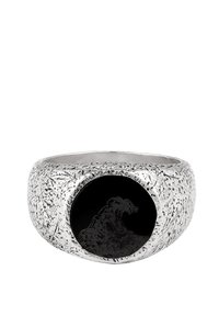 Silberner Ring mit strukturierten Oberfläche, der in der Mitte einen schwarzen Kreis zeigt, der ein Wellenmuster in Relief darstellt.