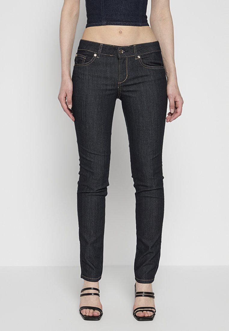 Jeans in denim scuro slim-fit con cinque tasche, cuciture a contrasto e chiusura con bottone. Il materiale ha una leggera elasticità e una consistenza liscia.