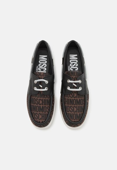 Zapatos negros y marrones con una parte superior estampada que presenta la palabra "MOSCHINO". Forma redondeada, ojales plateados y suela de goma blanca.