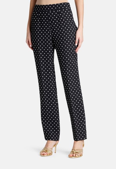 Pantalons noirs avec des pois blancs, taille haute, coupe droite, avec une texture de tissu lisse et des plis sur le devant.