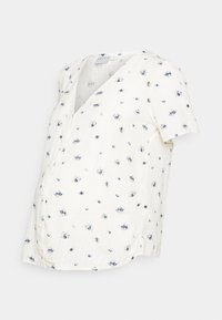 Blusa de maternidade branca de manga curta com decote em V, apresentando um padrão floral em azul, amarelo e preto, e detalhes em botão ao longo do lado.