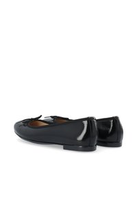Ballerine in vernice nera con punta tondeggiante, decorate con un dettaglio a fiocco sul davanti e bordo elasticizzato attorno all'apertura.