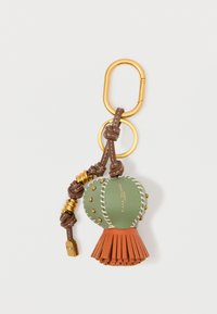 Klahvaketita accessor, millel on roheline nahkpall valge õmblusega, oranž pits alaosas, kuldne riistvara ja pruun punutud aas.