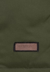 Dark green fabric with a smooth texture featuring a brown leather tag, embossed with "MARIKOO," attached with black stitching.