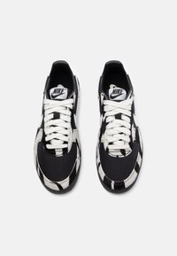 Sneaker con motivo in bianco e nero, con tomaia in tessuto, punta rotonda, lacci bianchi e marchio Nike sulla linguetta. Suola in gomma.
