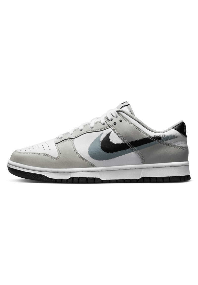 Sneaker Nike Dunk Low con una toma superiore in pelle grigia, punta bianca e accenti neri. Suola testurizzata con un design swoosh verniciato.