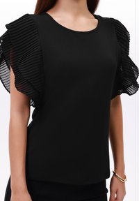 Czarna bluzka z okrągłym dekoltem i plisowanymi, przezroczystymi krótkimi rękawami. Korpus wykonany jest z gładkiego, jednolitego czarnego materiału.