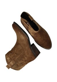 Bottines en suede marron avec un bout pointu et un faible talon. Présente des motifs de couture décoratifs et une languette à l'arrière.