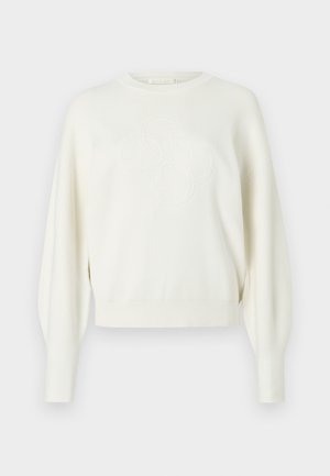 Hvid strikket sweater med cropped design, skuldersømme der falder, og præget logodetalje på fronten. Glat tekstur og ribstrikkede manchetter.