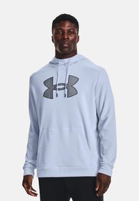Sweatshirt à capuche bleu clair en tissu doux, arborant un grand logo noir Under Armour sur le devant et une poche kangourou.