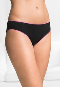 Perizoma in cotone nero con design a vita bassa e bordi scallop rosa. Texture liscia con dettagli di stile minimalista.
