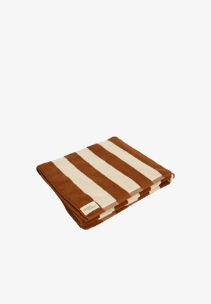 Serviette de plage pliée avec de larges rayures horizontales marron et crème et une petite étiquette beige dans un coin.