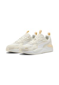 Beige sneakers met een mixed-material ontwerp, bestaande uit gaas, suede en synthetische elementen. Geaccentueerd met een lichtoranje label en logo.